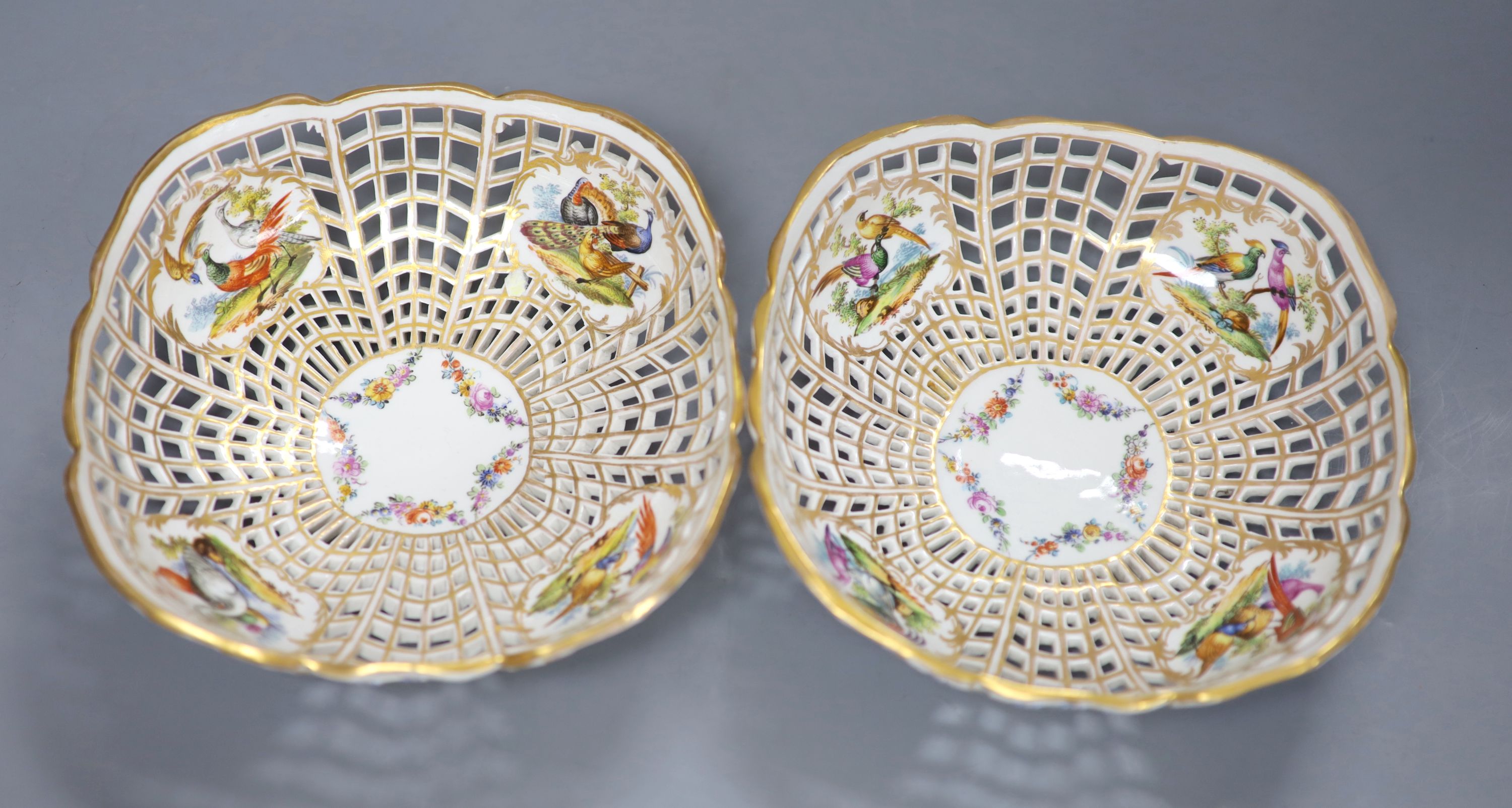 A pair of fine Continental pierced baskets, the panels painted with birds or flowers inside and out, blue Berlin style mark